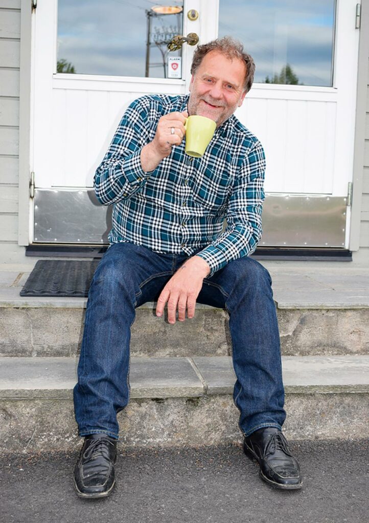 Bjørn Hansen, smilende med en kaffekopp